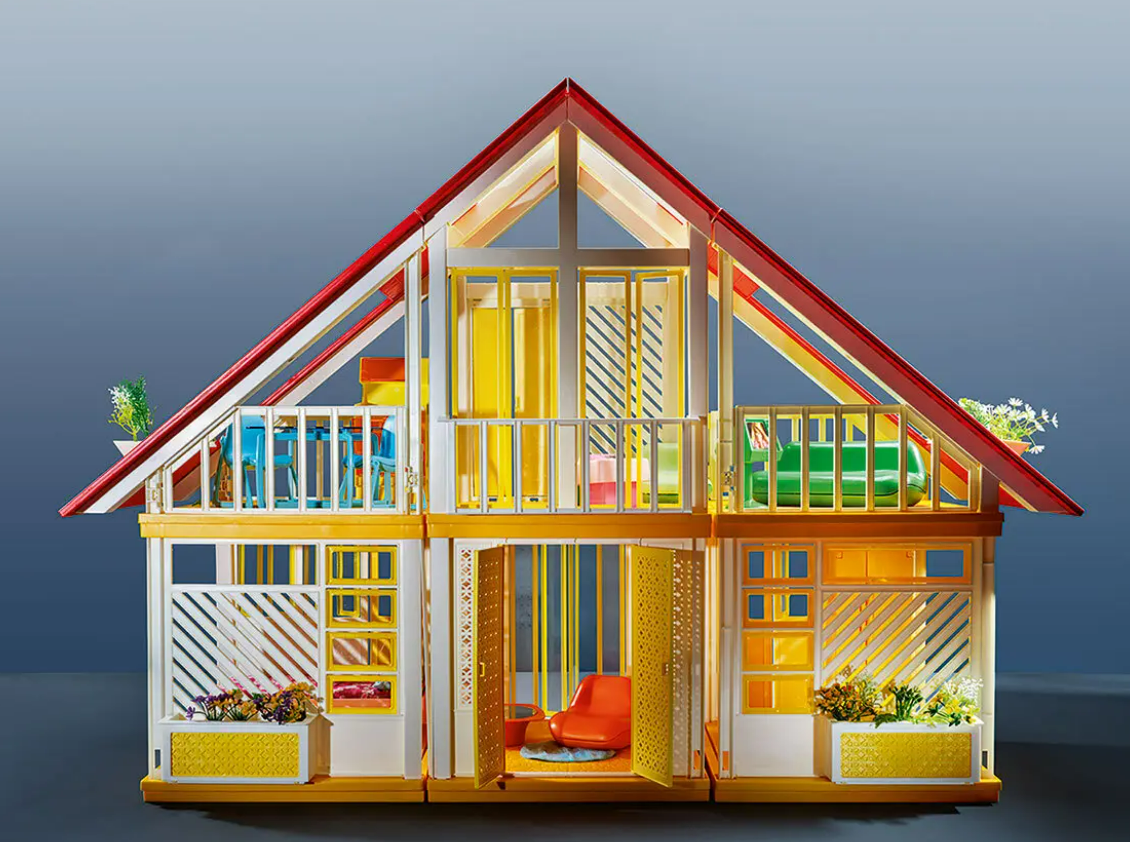 A frame yellow doll house filled with plants